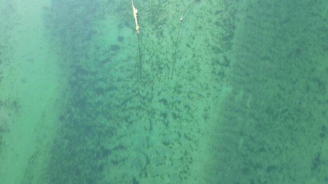 High Angle Footage of Beach and Ocean of Looe Town at River and Beach During Hot Sunny Day June 29th, 2025. Looe is a coastal town and civil parish in southeast Cornwall, England, United Kingdom.