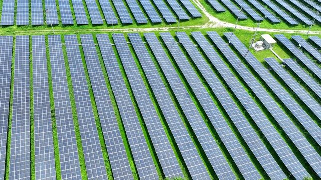 Solar arrays form geometric rows across lush green terrain, demonstrating how renewable technology and natural landscapes can coexist while supporting clean power generation and climate resilience.
