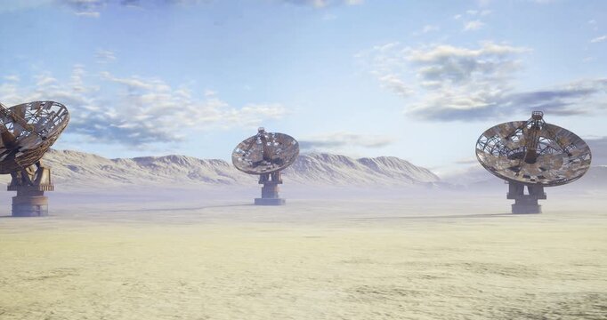 Scifi film set with giant parabolic props on barren plain, staged satellite dishes create cinematic scale under dramatic sky and mountain backdrop, production