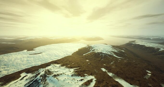 vast ice plain under soft golden light, gentle curvature of snowfield meeting distant sea, quiet mood ideal for background or editorial concept, tranquil