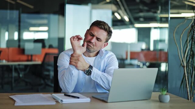 Businessman Suffering Wrist Pain While Working on Laptop