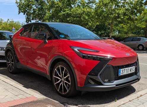 Vista en perspectiva de un autom&oacute;vil crossover urbano  Toyota C-HR Hybrid aparcado en una calle de Madrid, Espa&ntilde;a, 24 de junio de 2026