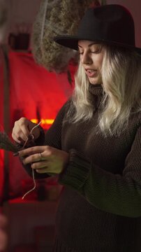 modern witch at home, amidst cobwebs and dried herbs, prepares a poison or a love potion, she arranges a bouquet near her cauldron and chants a spell. Black magic, occultism, sorceress, Halloween.