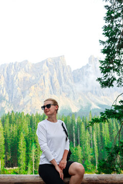 Mountain lake tourism close up. Beautiful female traveler with hiking backpack near a mountain lake. A young woman posing on a high mountain lake. Concept of freedom, tourism. Hiking tourism adv