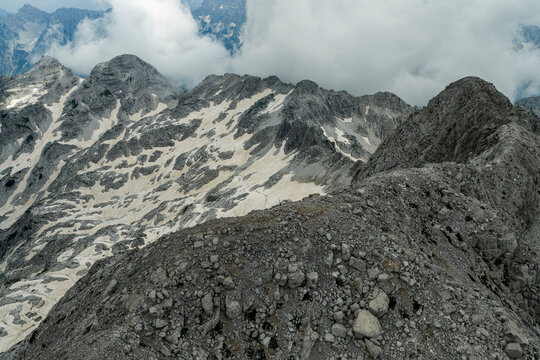 Jezerca High Alpine Mountain Landscape with Rocky Ridges, Seasonal Snowfields and Cloud-Covered Peaks