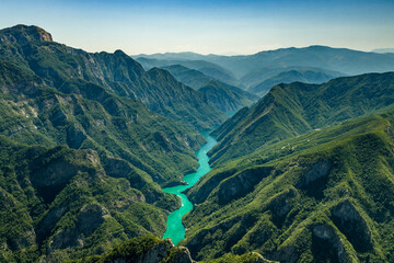 Obraz premium Turquoise Waterway Winding Through a Forested Mountain Canyon at Komani Lake