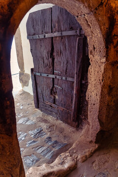 Old wooden door inside a stone passageway at Corvin Castle in Hunedoara Transylvania Romania