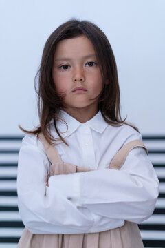 Serious Schoolgirl Standing with Arms Crossed