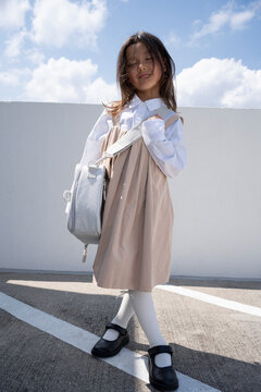 Young Schoolgirl Walking with Backpack Outdoors