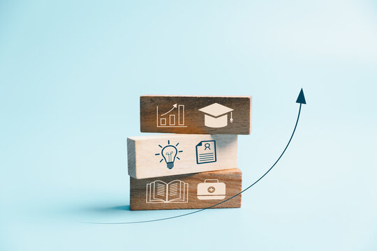 Education and professional growth concept with stacked wooden blocks, learning, certification and graduation icons, plus rising arrow, symbolizing skills, qualifications, progress and achievement.