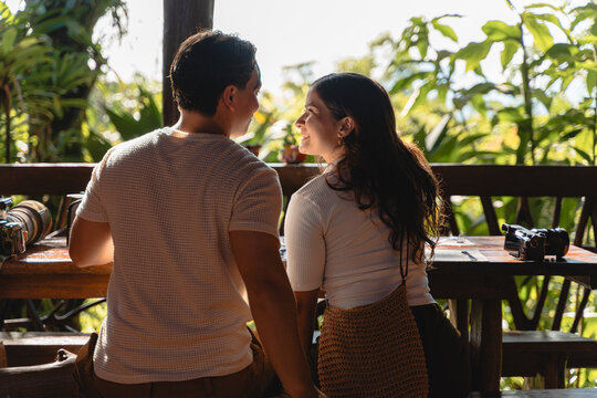 Couple enjoying romantic conversation on tropical vacation balcony