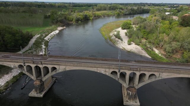 Milan &ndash; Pavia &ndash; Genoa railway line: drone view of a regional train and an Intercity train crossing the bridge over the Ticino River in Pavia, Italian Railways and the modernization of the rail network