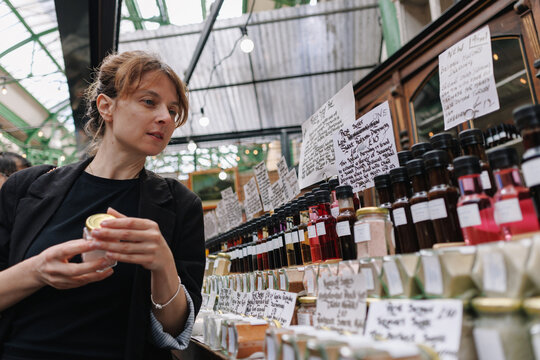 Woman shopping for gourmet condiments at London market
