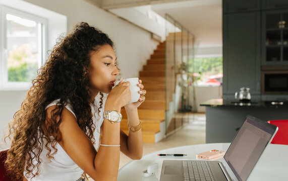 Woman Drinking Coffee Near Laptop