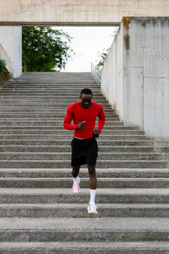 A full-body shot of a professional runner working out in a park