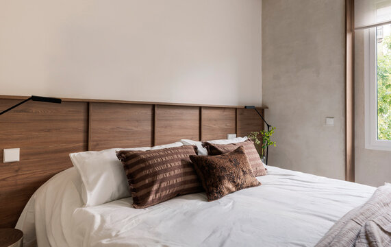 Textured pillows on wooden headboard bed