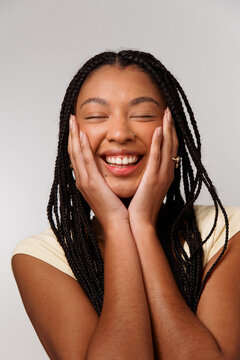 Woman Smiles With Joy While Holding Her Face With Hands