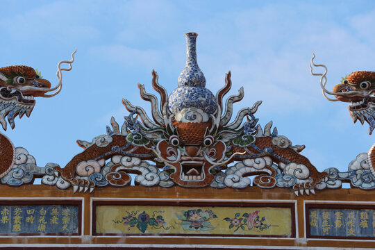 Traditional blue and white porcelain gourd vase and imperial dragon mosaic on ancient pagoda roof ridge, oriental ceramic shards artwork