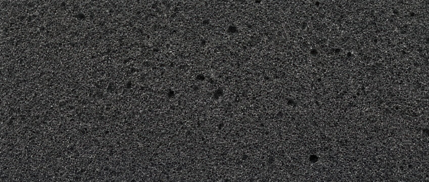 Macro texture of black acoustic foam sponge. Sound absorbing porous insulation material surface