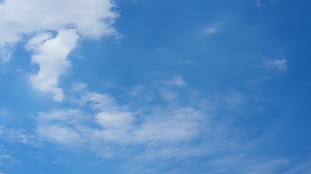 A blue sky cloud timelapse video showing scattered cumulus and altocumulus clouds drifting with gentle winds, soft sunlight, clear air, and changing fair weather across the bright atmosphere.
