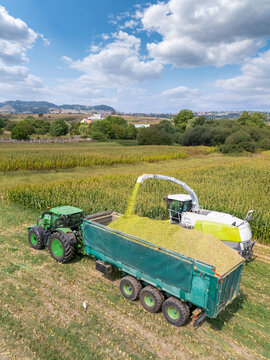 Aerial view of a forage harvester collecting corn and loading it into a tractor trailer