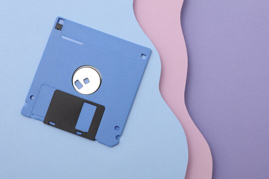 Vntage floppy disk from 80s on cut paper background of wavy layers. Retro wave. Creative layout. Minimalism
