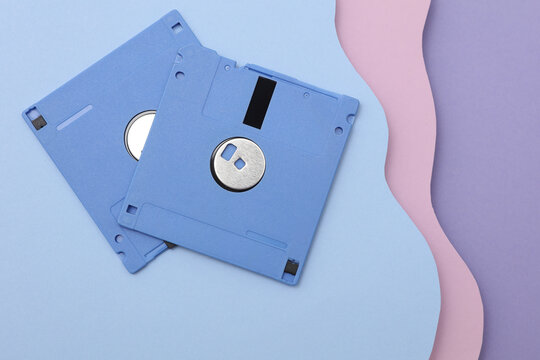Vntage floppy disks from 80s on cut paper background of wavy layers. Retro wave. Creative layout. Minimalism