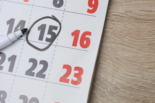 Paper calendar on the table with the number 15 circled.