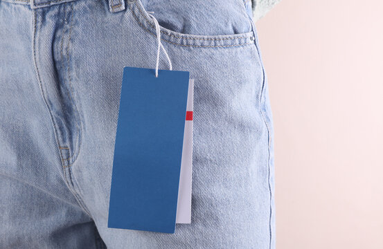 Blank blue sale tag in front pocket of blue jeans on a woman