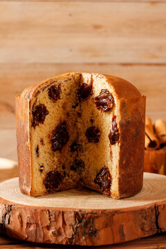 Delicious artisanal chocolate panettone displayed on a rustic wooden table during a Christmas celebration.