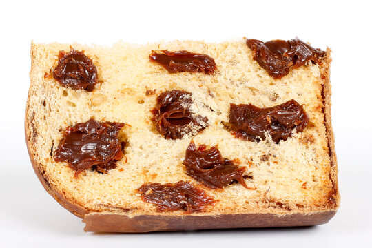 Slice of chocolate chip panettone with soft, airy dough, isolated on a white background.