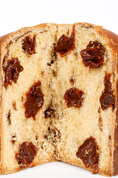 Traditional sliced chocolate Christmas panettone with creamy filling, isolated on a white background.
