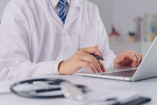 Doctor Using Laptop with Stethoscope for Digital Healthcare Medical Records Telemedicine Clinical Technology and Patient Care Workflow