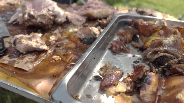 Close-up video footage of a chef wearing black gloves using a sharp knife to slice freshly smoked barbecue meat on butcher paper.
