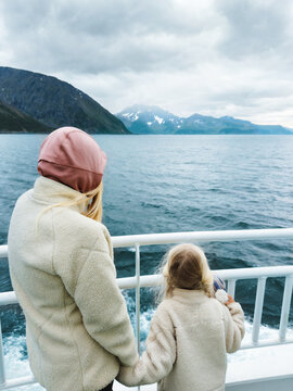 Family journey through Norwegian fjords mother with child enjoying ferry cruise cold sea scenery, outdoor vacation tourism adventure Arctic tour travel with children