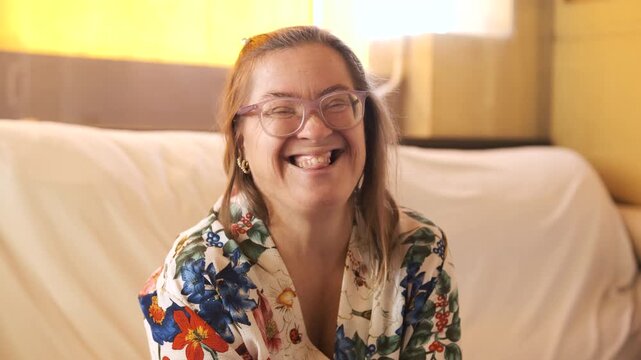 Authentic portrait of a happy woman with Down syndrome laughing and smiling genuinely. Concept of inclusion, diversity, and special needs