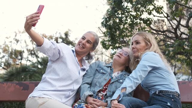 Happy family sitting on a bench in the park, taking selfies and enjoying quality time together under the sunny sky