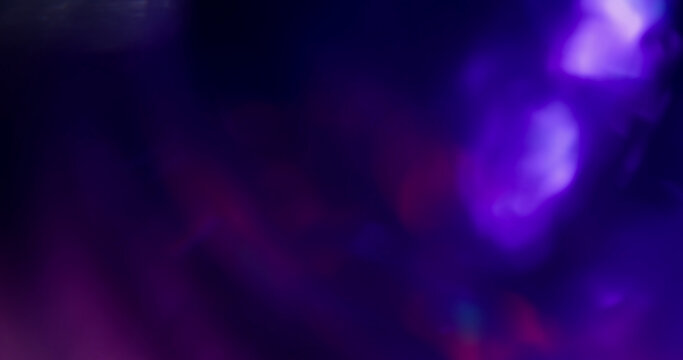 Defocused glow. Color light flare. Blur blue purple pink optical texture illuminated glint on art neon kaleidoscope bokeh dark black background.