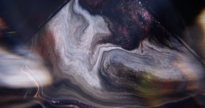 Ink spill. Sparkling fluid. Defocused purple color pigment glitter mix acrylic texture floating on abstract light art background.