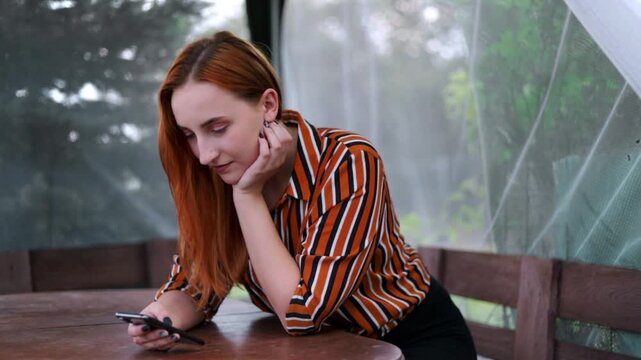Young Woman Using Smartphone Outdoors at Table