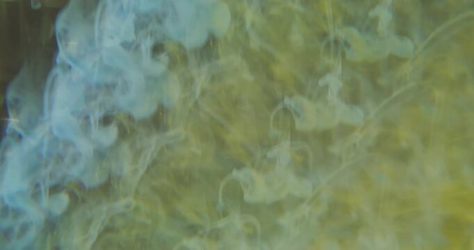 Defocused paint cascade. Fog water. Yellow blue color cloud vapor underwater rainbow steam pigment spreading on abstract art light background.