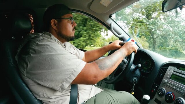 Profile shot of a professional tour guide driving a car through the jungle of Costa Rica. User generated content from an adventure