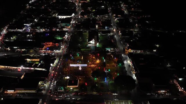 Illuminated streets of La Fortuna in Costa Rica during christmas holidays. Aerial view of the city with traffic and a decorated central park