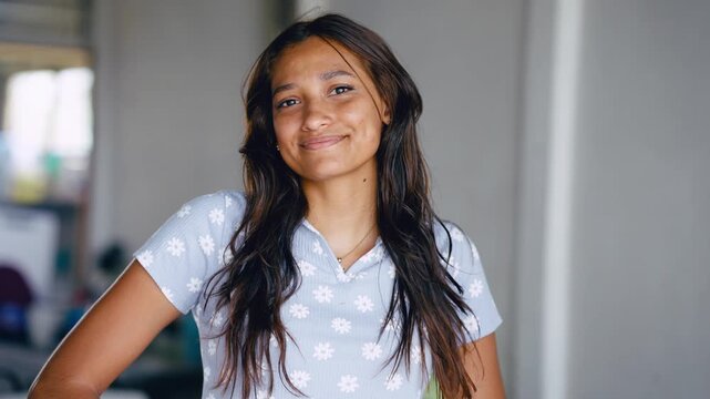 Beautiful hispanic woman with long dark hair smiling and posing. Positive and confident female person looking at camera with a joyful expression
