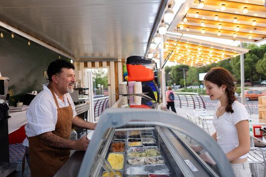 Ice cream vendor serving smiling customer in food truck