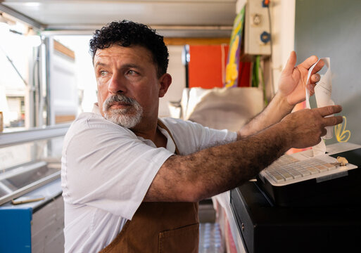 Small business owner calculating expenses and looking away