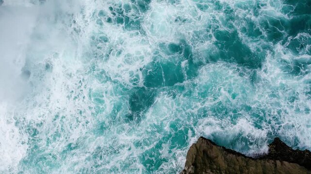 Aerial Tilt Up from Crashing Waves to Tourists on Rocky Coastline, Devil Tears Nusa Lembongan