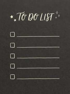 Handwritten to do list on a dark charcoal textured paper background