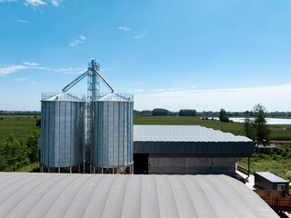 Large agricultural grain silo facility under blue sky © zhu difeng