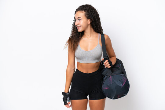 Young sport Arab woman with sport bag isolated on white background looking side